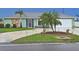Charming single-story home featuring a manicured lawn, mature palm trees, and an attached two-car garage at 1198 Jamaica Rd, Venice, FL 34293