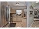 Well-lit kitchen featuring stainless steel appliances, tile flooring and backsplash, and an open layout to the living area at 1198 Jamaica Rd, Venice, FL 34293