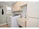 Functional laundry room equipped with a modern washing machine, utility sink, and ample cabinet storage at 1198 Jamaica Rd, Venice, FL 34293