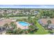 Aerial view of community pool surrounded by lush landscaping, palm trees, and well-maintained homes at 1211 Capri Isles Blvd # 6, Venice, FL 34292