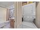 Compact laundry with bathroom featuring stacked washer/dryer and stylish vanity with patterned wallpaper at 1211 Capri Isles Blvd # 6, Venice, FL 34292