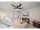Bright bedroom with modern ceiling fan, television, comfortable bed, and charming console table at 1211 Capri Isles Blvd # 6, Venice, FL 34292