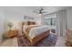 Cozy bedroom with a wood-frame bed, soft linens, and natural light from the window at 1211 Capri Isles Blvd # 6, Venice, FL 34292