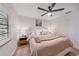 Cozy bedroom featuring a ceiling fan, natural light, and a comfortable bed with a plush throw blanket at 1211 Capri Isles Blvd # 6, Venice, FL 34292