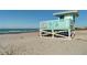 Turquoise lifeguard stand on sandy beach, offering ocean views and safety for swimmers at 1211 Capri Isles Blvd # 6, Venice, FL 34292
