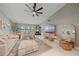 Spacious living room boasts modern fan, large windows, and comfortable seating arrangement at 1211 Capri Isles Blvd # 6, Venice, FL 34292