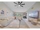 Well-lit living room with a ceiling fan, plush sofas, and an entertainment center at 1211 Capri Isles Blvd # 6, Venice, FL 34292