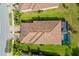 Aerial shot showcases the residence's pool, red tile roof, brick driveway, and manicured lawn, set in a beautiful neighborhood at 12187 Amica Loop, Venice, FL 34293