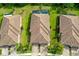 An aerial view of residences with red tile roofs, lush green lawns, and private pools, showcasing a well-manicured community at 12187 Amica Loop, Venice, FL 34293