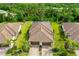 Aerial view of villa featuring a beautiful tile roof, lush landscaping, and a brick paver driveway at 12187 Amica Loop, Venice, FL 34293