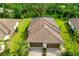 Aerial view of villa featuring a beautiful tile roof, lush landscaping, and a brick paver driveway at 12187 Amica Loop, Venice, FL 34293