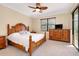 Serene bedroom with wooden furniture, complemented by a window and lanai access at 12187 Amica Loop, Venice, FL 34293