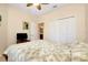 Cozy bedroom with a ceiling fan, closet, and television creating a comfortable space at 12187 Amica Loop, Venice, FL 34293