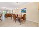 Open concept dining area with table, seating four, chandelier, neutral walls, and artwork at 12187 Amica Loop, Venice, FL 34293
