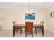 Dining area featuring a wooden table with seating for four, neutral walls, and tiled flooring at 12187 Amica Loop, Venice, FL 34293