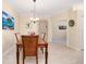 Dining area with wooden table, chairs, neutral paint, and tiled floors, viewed from behind one side at 12187 Amica Loop, Venice, FL 34293