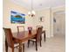 Dining table set for four with wood chairs, neutral wall paint, tile flooring, and neutral decor at 12187 Amica Loop, Venice, FL 34293
