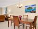 Dining table is set in an open-concept room with living area, chandelier, and neutral wall paint at 12187 Amica Loop, Venice, FL 34293