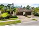 Villa featuring a beautiful tile roof, lush landscaping, and a brick paver driveway at 12187 Amica Loop, Venice, FL 34293