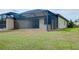 Back exterior of house with screen lanai, yard, and partial view of nearby houses at 12187 Amica Loop, Venice, FL 34293