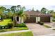 Villa featuring a beautiful tile roof, lush landscaping, and a brick paver driveway at 12187 Amica Loop, Venice, FL 34293