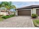 Garage featuring lush landscaping and a well-maintained driveway at 12187 Amica Loop, Venice, FL 34293