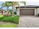 Garage with meticulously maintained landscaping and beautiful pavers at 12187 Amica Loop, Venice, FL 34293