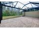 Open-air screened lanai with brick flooring, offering a seamless transition to the surrounding green backyard at 12187 Amica Loop, Venice, FL 34293