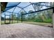 Spacious screened-in lanai with brick flooring and a beautiful view of the lush greenery and backyard at 12187 Amica Loop, Venice, FL 34293