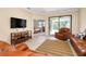 Open living room with TV, access to the bedroom, and a screened lanai at 12187 Amica Loop, Venice, FL 34293