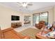 Comfortable living room with a TV and view to a bedroom and screened patio at 12187 Amica Loop, Venice, FL 34293