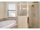 Soaking tub and shower enclosure with window in bathroom at 12187 Amica Loop, Venice, FL 34293