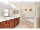 Double vanity and soaking tub in main bathroom at 12187 Amica Loop, Venice, FL 34293