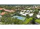 Community aerial view showcasing lush landscaping and a tennis court for active lifestyles at 1234 Harbor Town Way, Venice, FL 34292