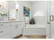 Lovely bathroom features a double sink vanity, soaking tub and frameless glass shower at 1234 Harbor Town Way, Venice, FL 34292