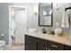 Classic bathroom with dark vanity, stone countertop, framed mirror, and adjacent doorway to bedroom at 1234 Harbor Town Way, Venice, FL 34292