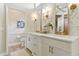 Bathroom featuring double vanity with gold fixtures and modern white cabinets at 1234 Harbor Town Way, Venice, FL 34292
