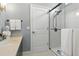 Bright bathroom with a tiled walk-in shower, neutral wall color, and a dark vanity with a light countertop at 1234 Harbor Town Way, Venice, FL 34292