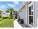 Paver pathway leads to home's entrance surrounded by lush landscaping and mature palm trees at 1234 Harbor Town Way, Venice, FL 34292