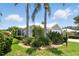 Landscaped lawn with palms and low shrubbery complement this single-story home's neutral palette at 1234 Harbor Town Way, Venice, FL 34292