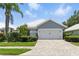 Charming single-story home with a two-car garage, paver driveway and lush landscaping at 1234 Harbor Town Way, Venice, FL 34292