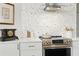 Modern kitchen with white cabinets, updated appliances, and stylish tile backsplash at 1234 Harbor Town Way, Venice, FL 34292