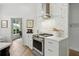 Bright kitchen with white cabinets, gold hardware, stainless steel appliances, island, and decorative tile backsplash at 1234 Harbor Town Way, Venice, FL 34292