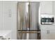 Kitchen with stainless steel refrigerator, white cabinetry, gold hardware, and stainless steel microwave at 1234 Harbor Town Way, Venice, FL 34292