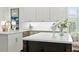 Bright kitchen featuring white cabinets, a large island with a white countertop, and stainless steel appliances at 1234 Harbor Town Way, Venice, FL 34292