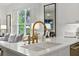 Bright kitchen with white countertops, brass hardware, stainless steel appliances, and view to Gathering room at 1234 Harbor Town Way, Venice, FL 34292
