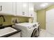 Bright laundry room with front-load washer/dryer, white cabinets, and sink at 1234 Harbor Town Way, Venice, FL 34292