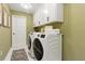 Well-equipped laundry room with front-load washer/dryer, white cabinets, and tiled floor at 1234 Harbor Town Way, Venice, FL 34292