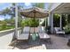 Outdoor screened patio with lounge chairs and table with umbrella at 1234 Harbor Town Way, Venice, FL 34292