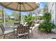Outdoor patio with patio table and chairs, umbrella, view to the pond at 1234 Harbor Town Way, Venice, FL 34292
